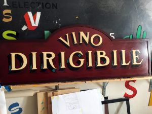 Antica insegna Vino Dirigibile, dipinta a mano su lamiera di ferro Antica insegna Vino Dirigibile, dipinta a mano su lamiera di ferro